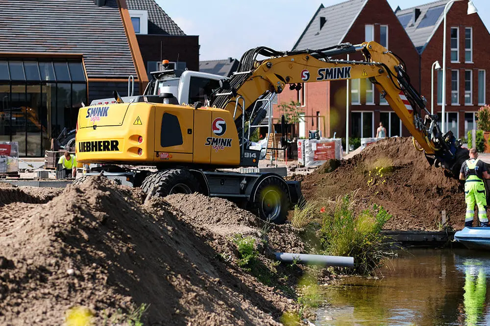 Een Smink-graafmachine aan het werk bij de aanleg van een woonwijk