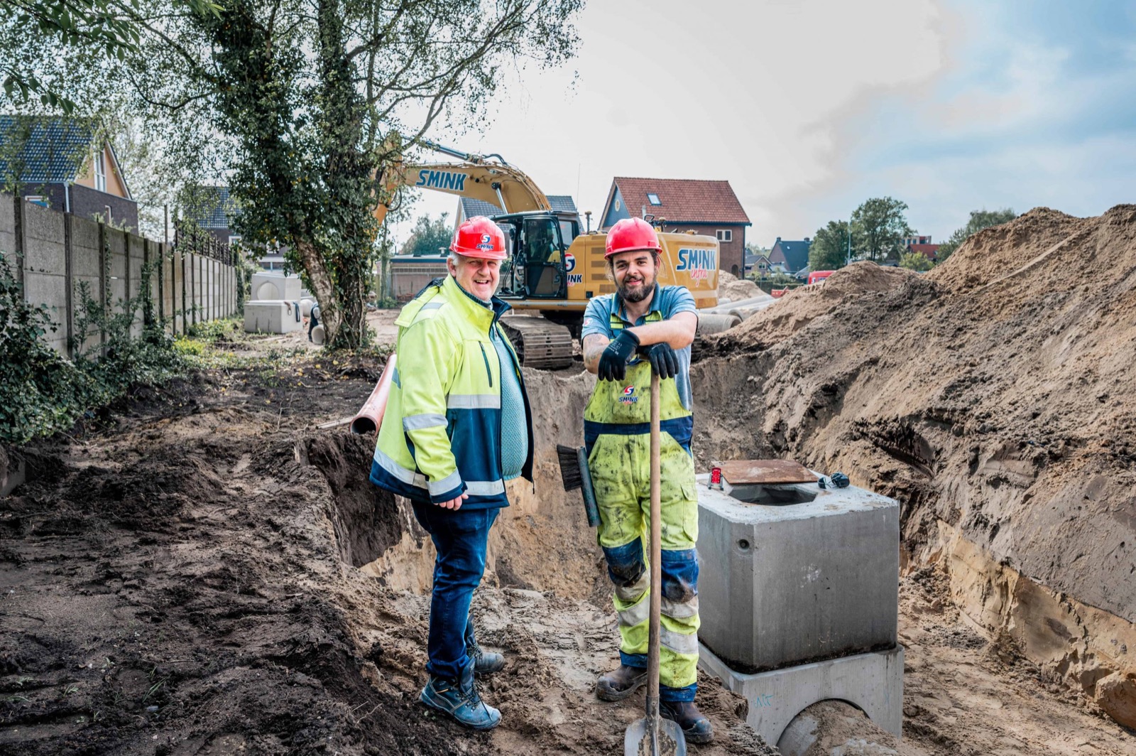 Twee medewerkers van Smink Infra op de werklocatie in een woonwijk