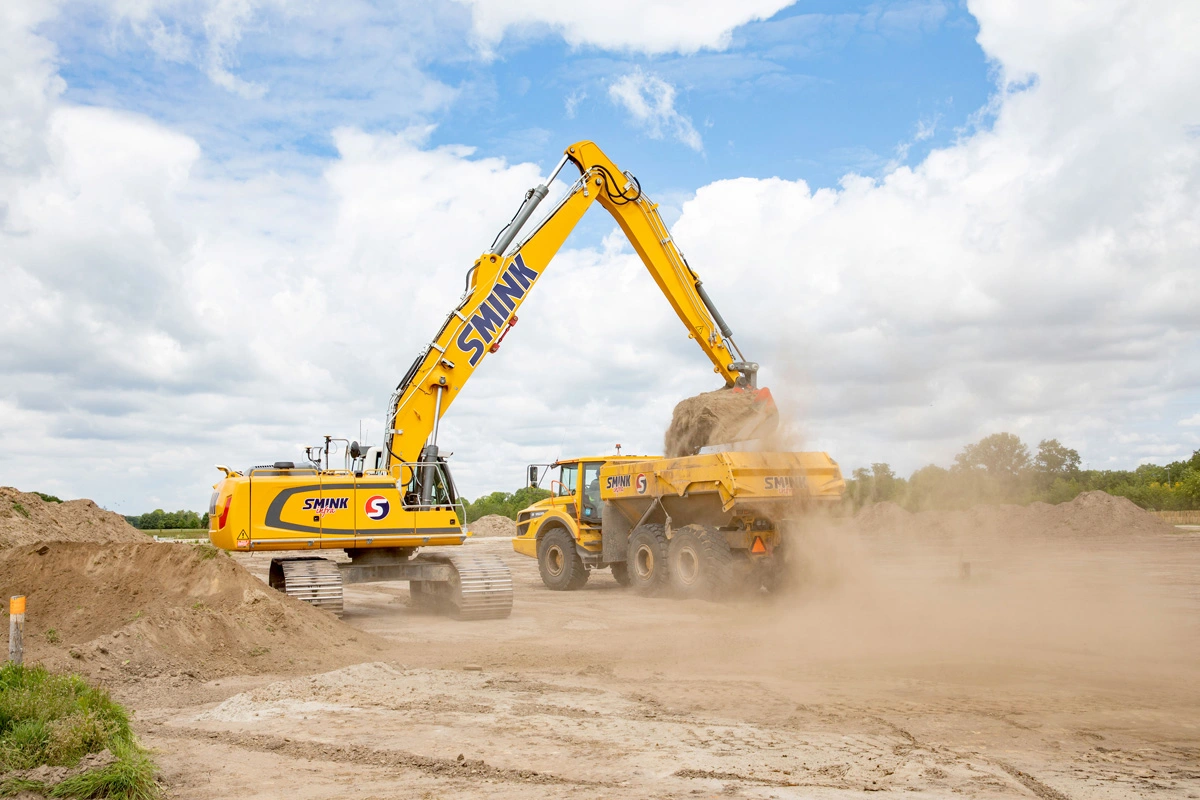 Smink-graafmachine laadt grond in een dumper bij Woonpark Hoevelaken